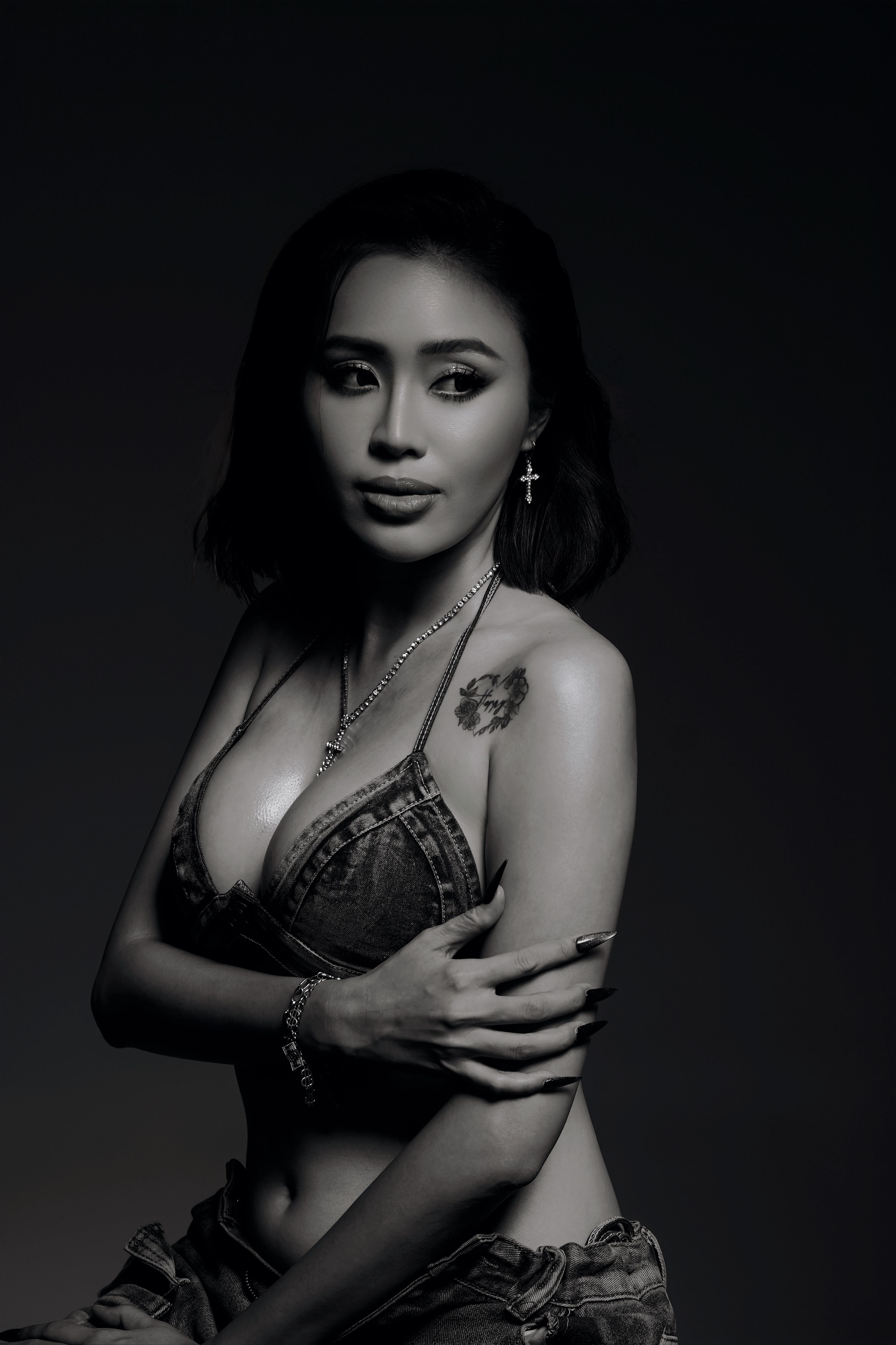Stunning black and white portrait of a woman with striking tattoo and jewelry.