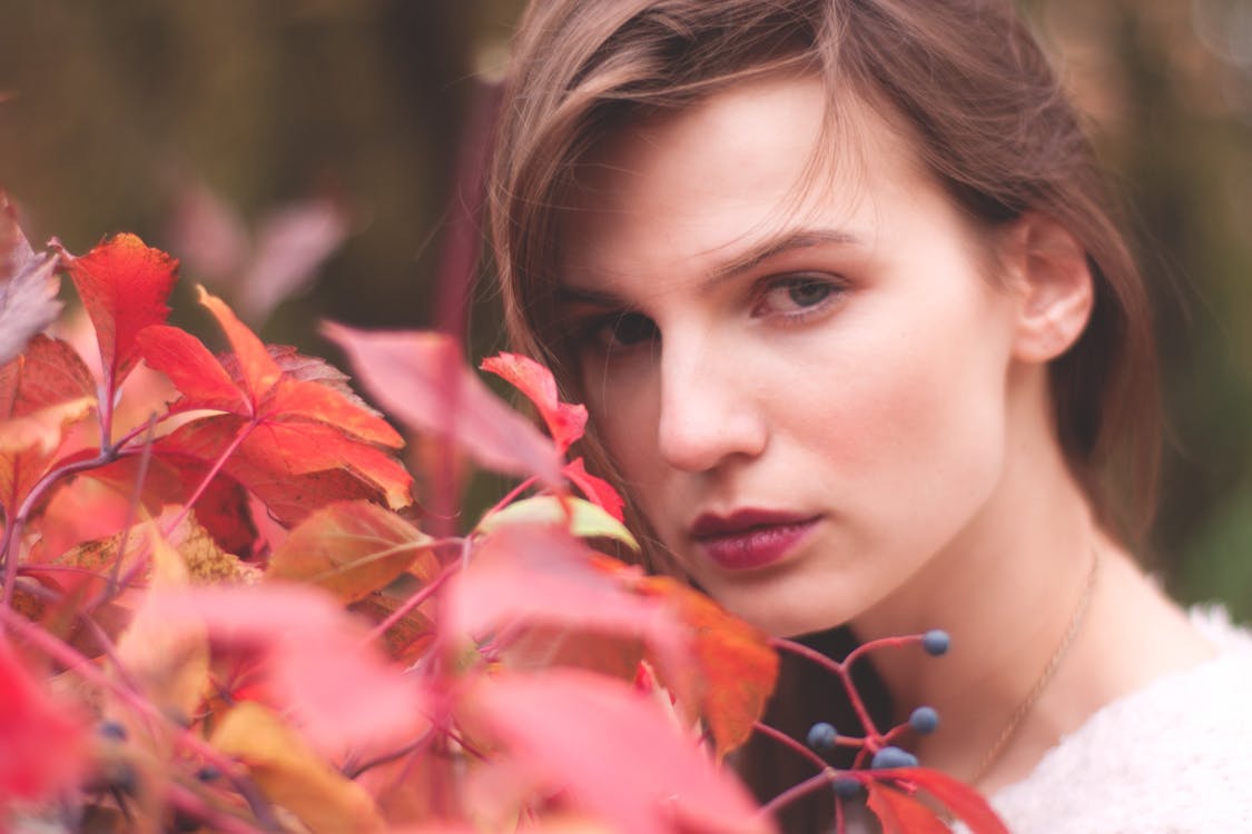 Free Woman Standing Near Red Leaf Plant Stock Photo