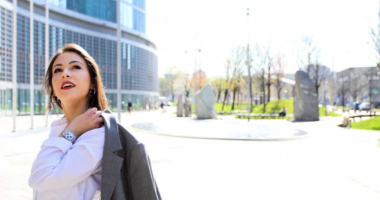 Free Woman Carrying Blazer Looking up on Sidewalk Stock Photo