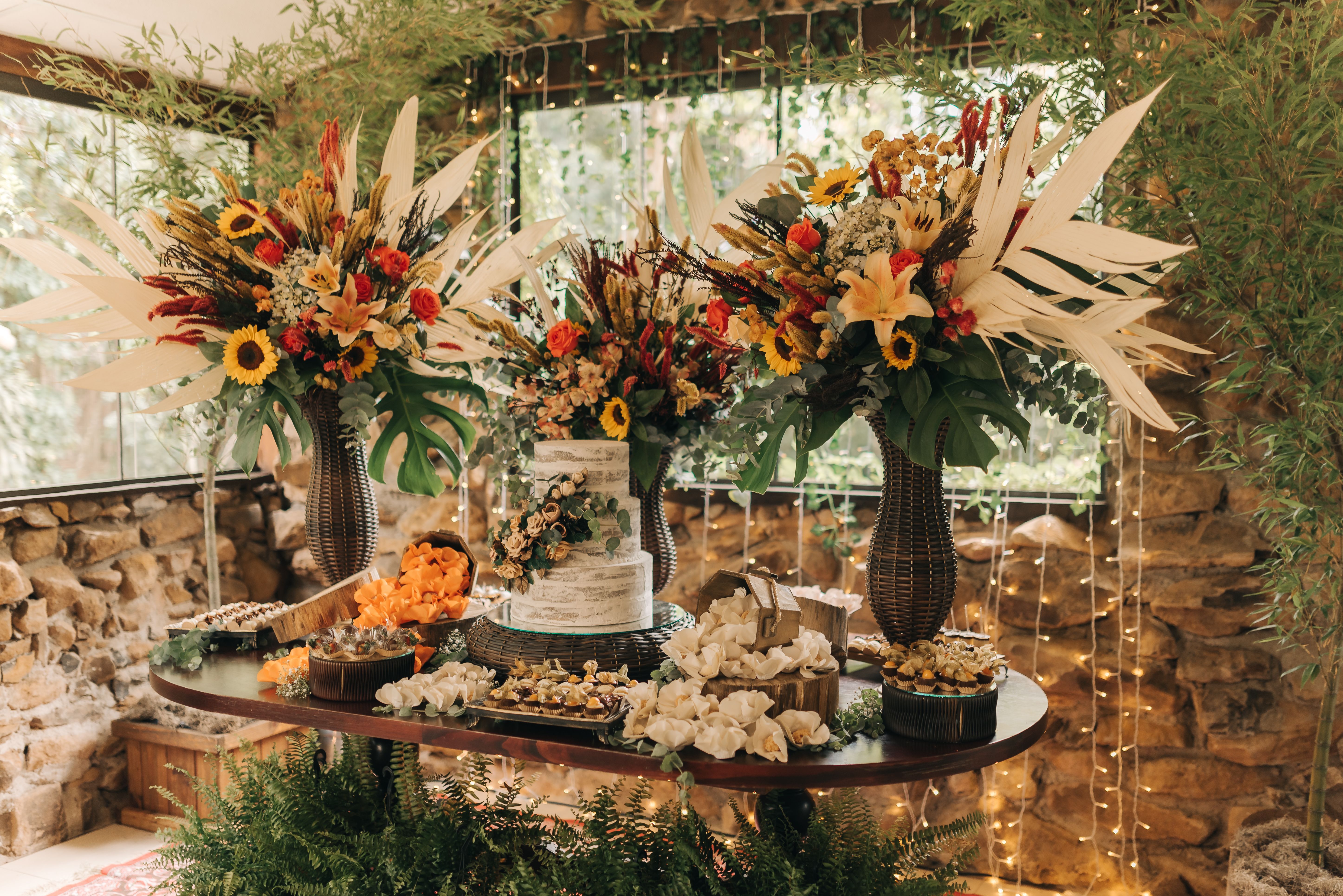 Beautiful rustic wedding decor with vibrant floral arrangements and a stylish cake setup.