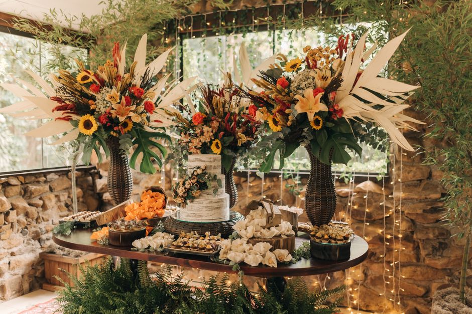 Beautiful rustic wedding decor with vibrant floral arrangements and a stylish cake setup.