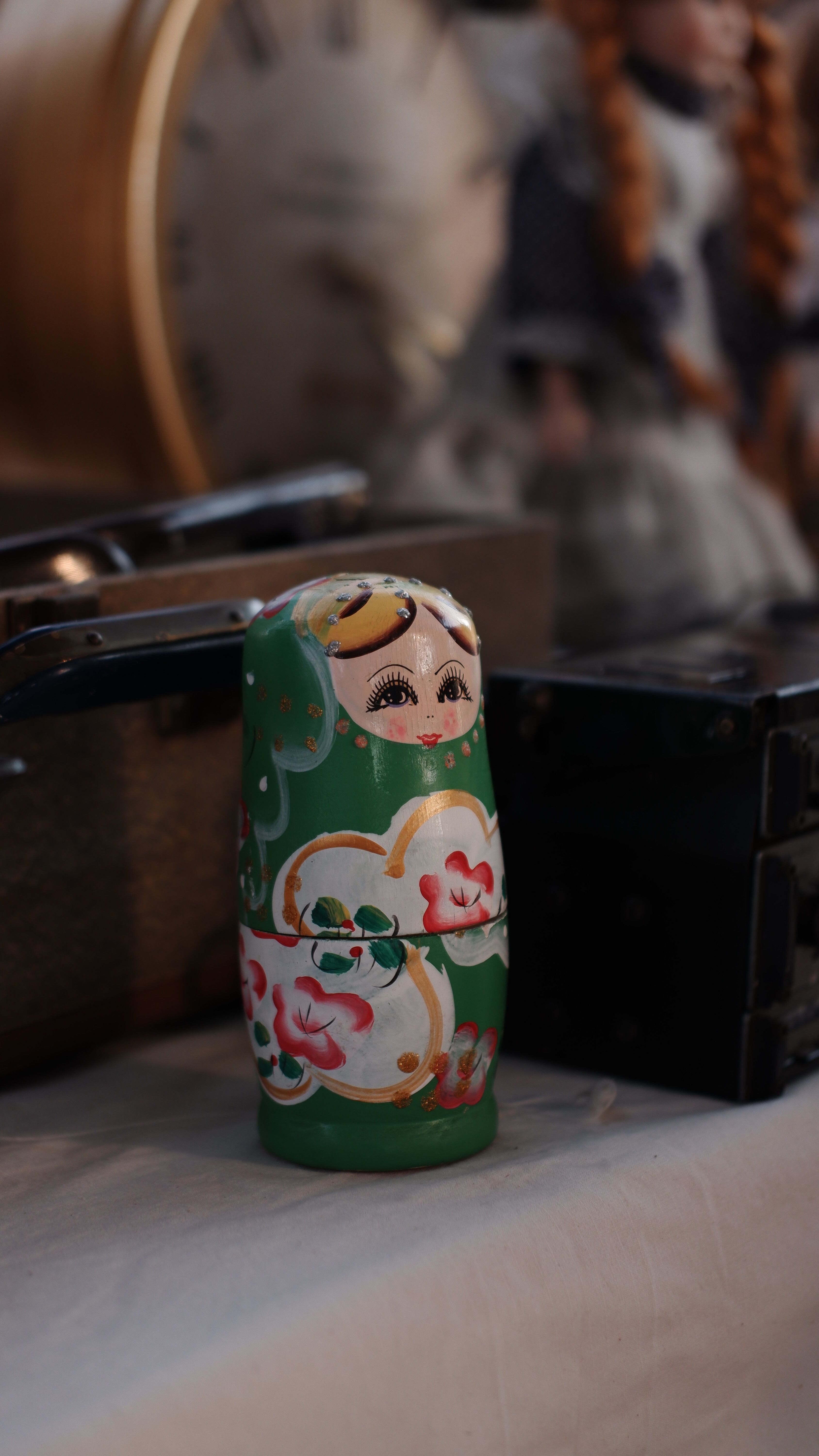 Green Matryoshka doll displayed with vintage items for a classic look.