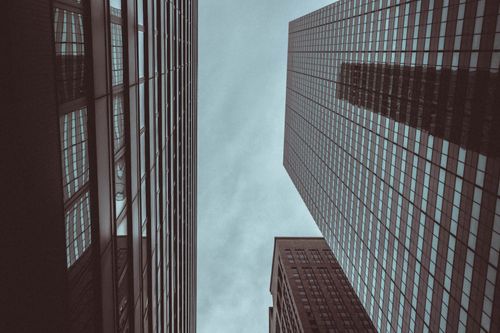 Free Looking up at skyscrapers in New York City with cloudy sky, showcasing architectural grandeur. Stock Photo