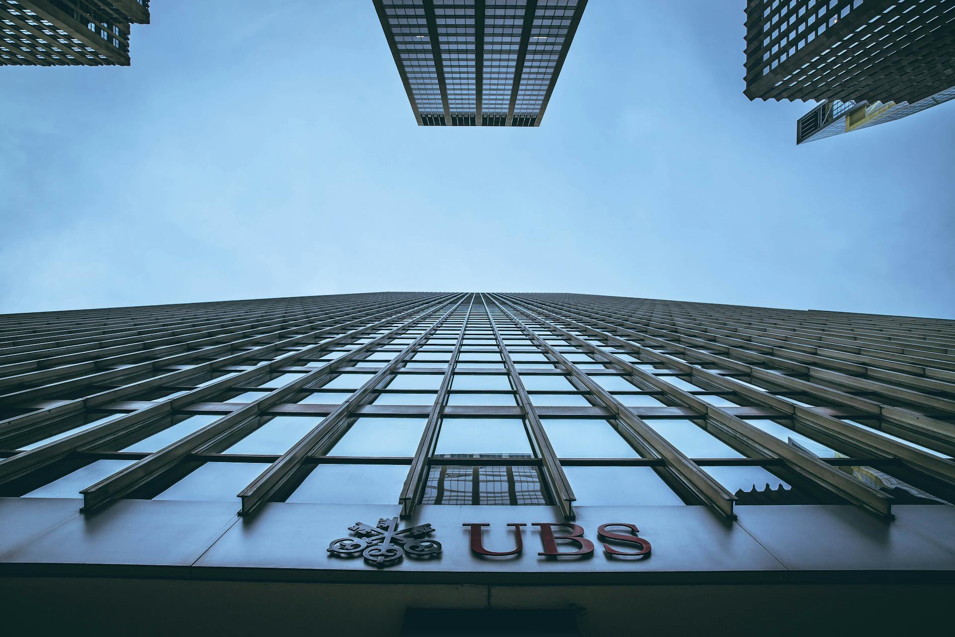 Low angle view of New York skyscrapers with UBS logo, emphasizing height and urban architecture.