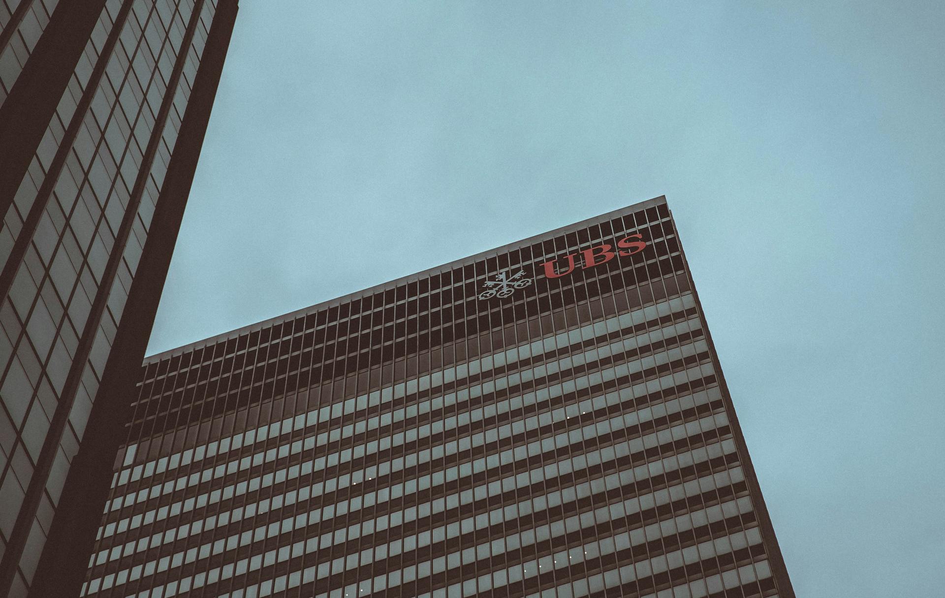 Modern skyscraper featuring the UBS logo against a clear sky in New York City.