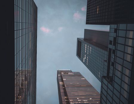 Dramatic view of tall skyscrapers in New York against a blue sky.
