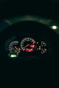 A vibrant, illuminated car dashboard captured at night, showcasing detailed instrument panels.