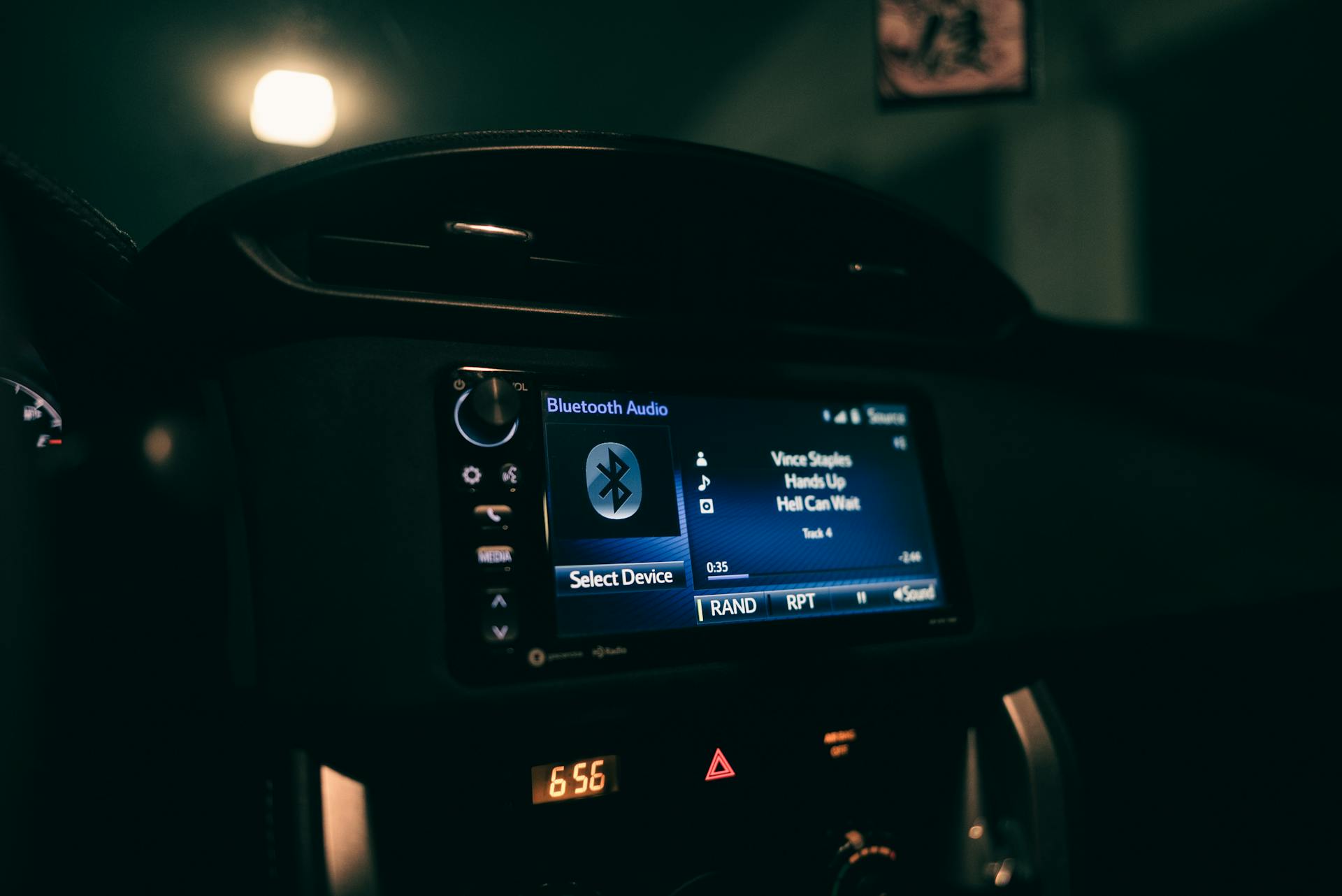 Close-up view of a car's dashboard at night displaying Bluetooth audio system.