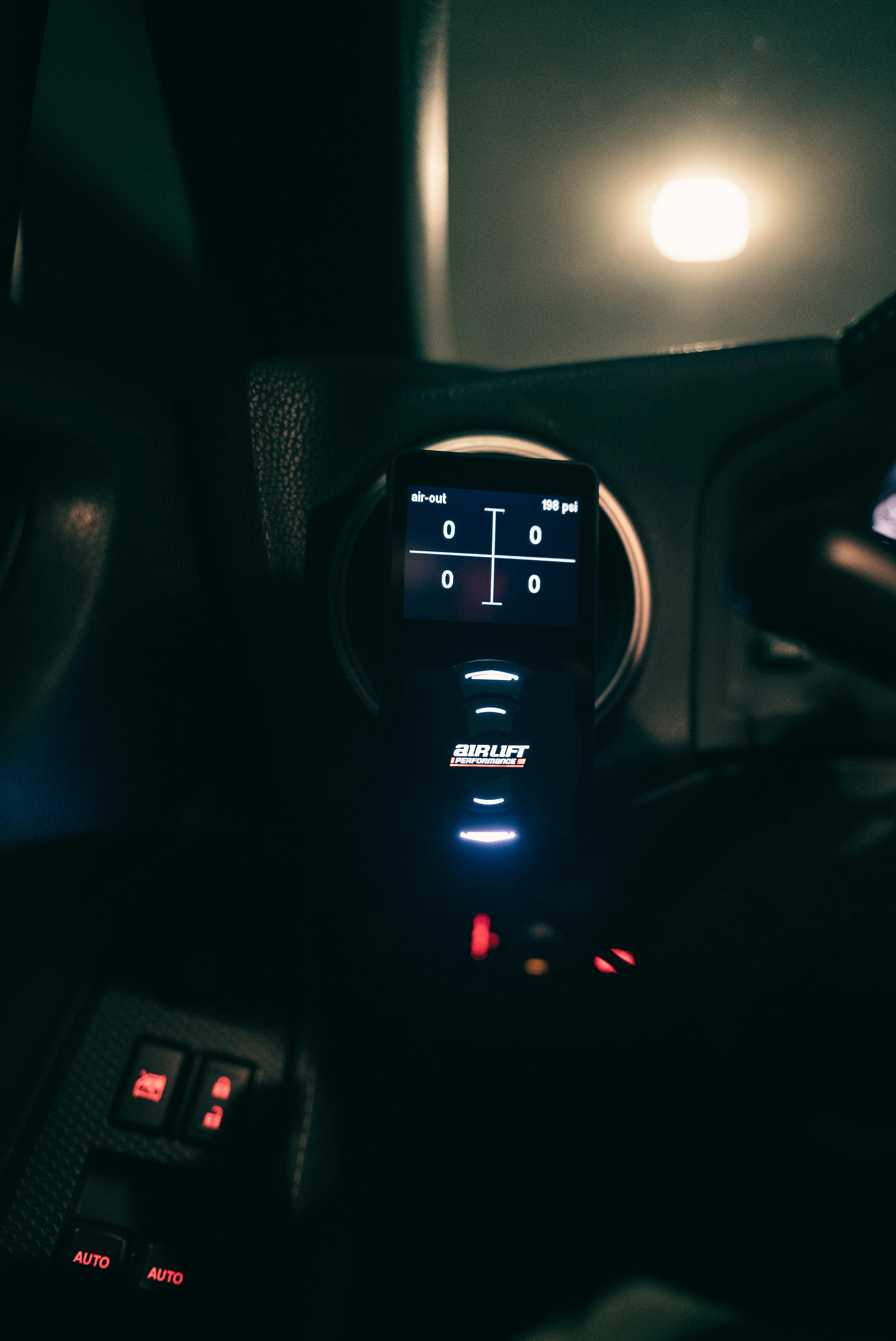 Free Close-up of a digital automotive control device inside a car interior at night. Stock Photo