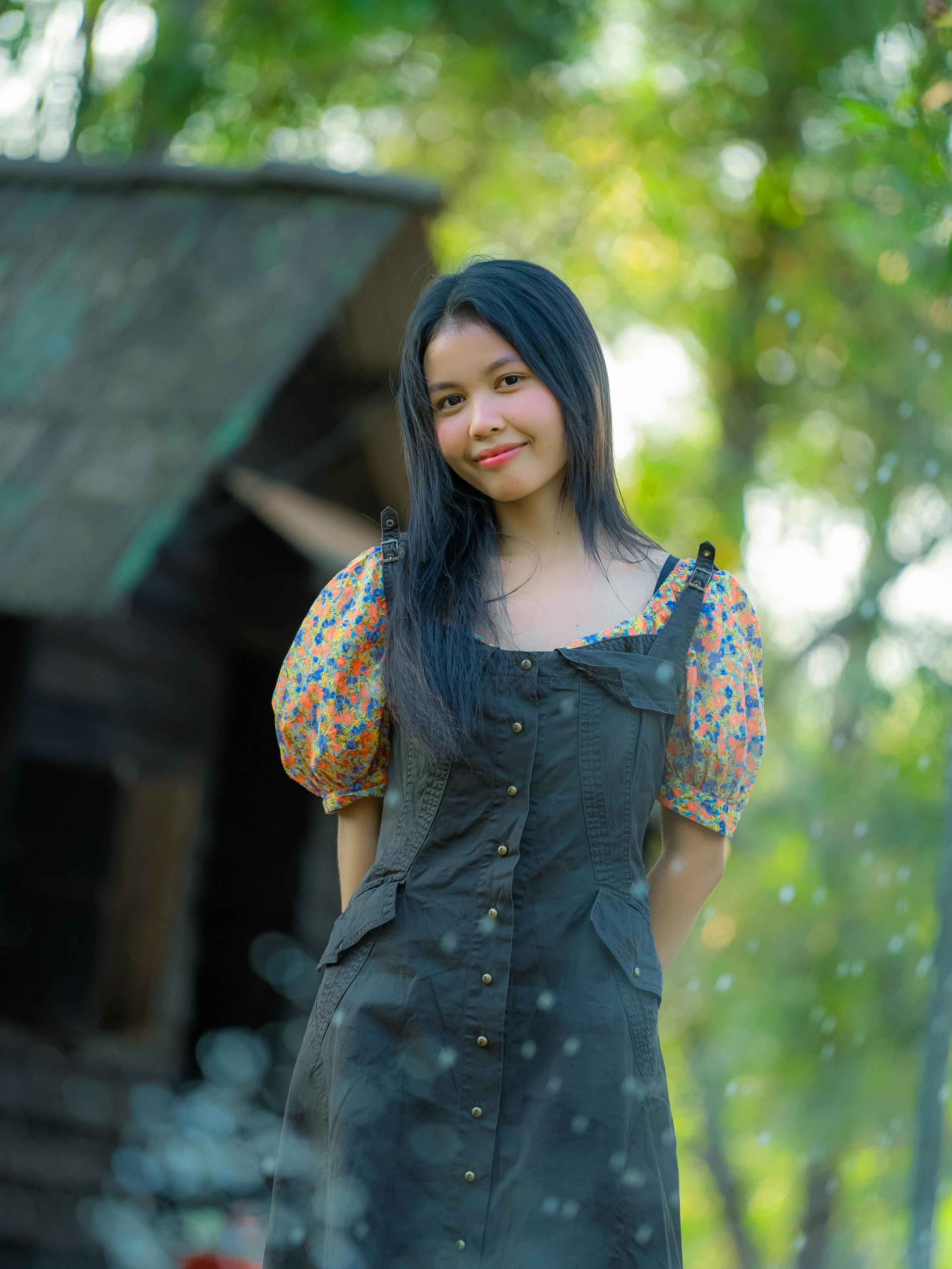 Zadarmo Mladá žena sa usmieva v pulzujúcom vonkajšom prostredí v Kambodži s bujnou zeleňou. Fotka z fotobanky