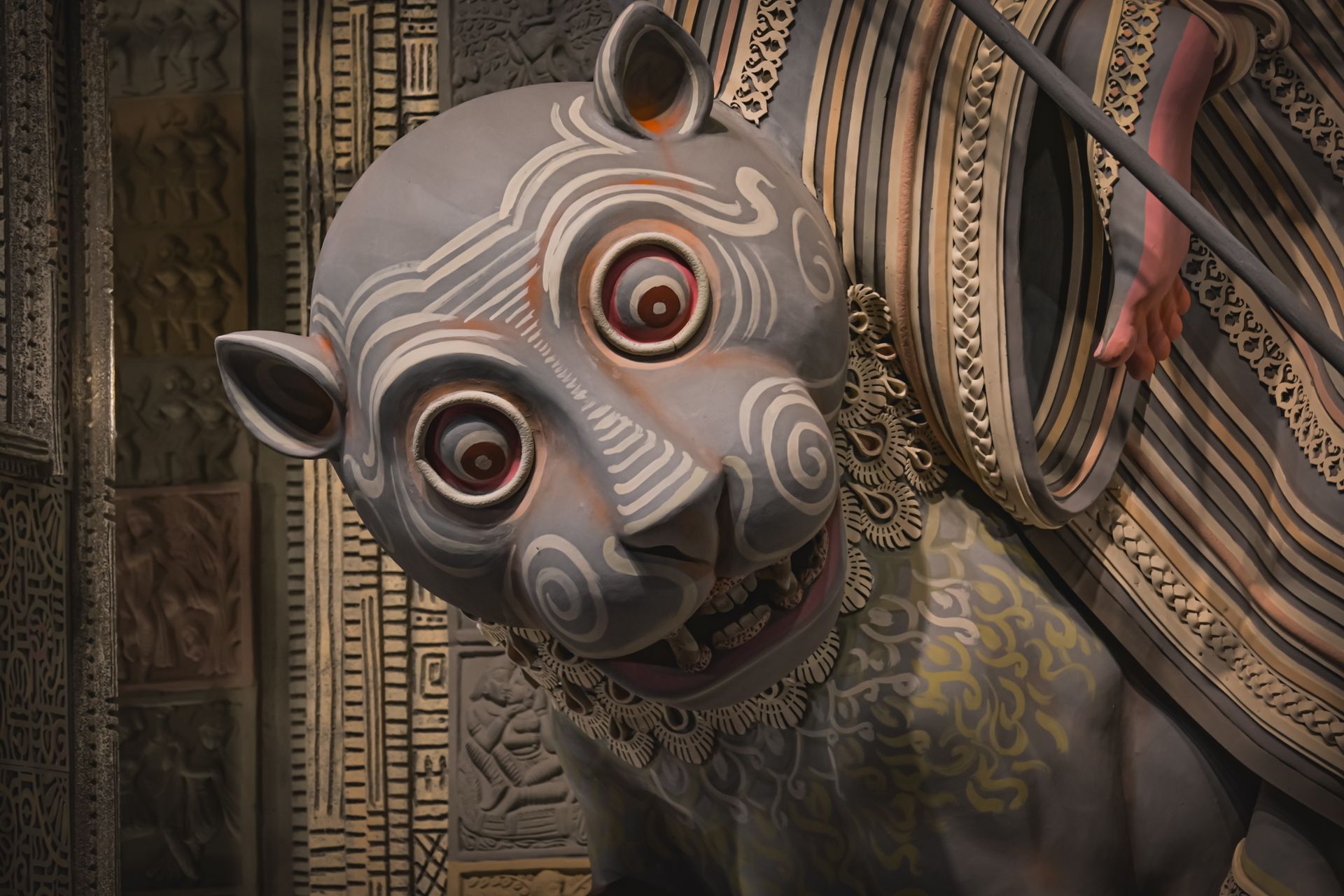 Close-up of an intricate animal sculpture with swirling patterns at a Kolkata festival.