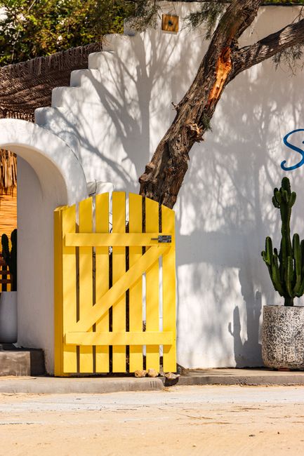A vibrant yellow door against a whitewashed wall on Naxos island captures Aegean style.