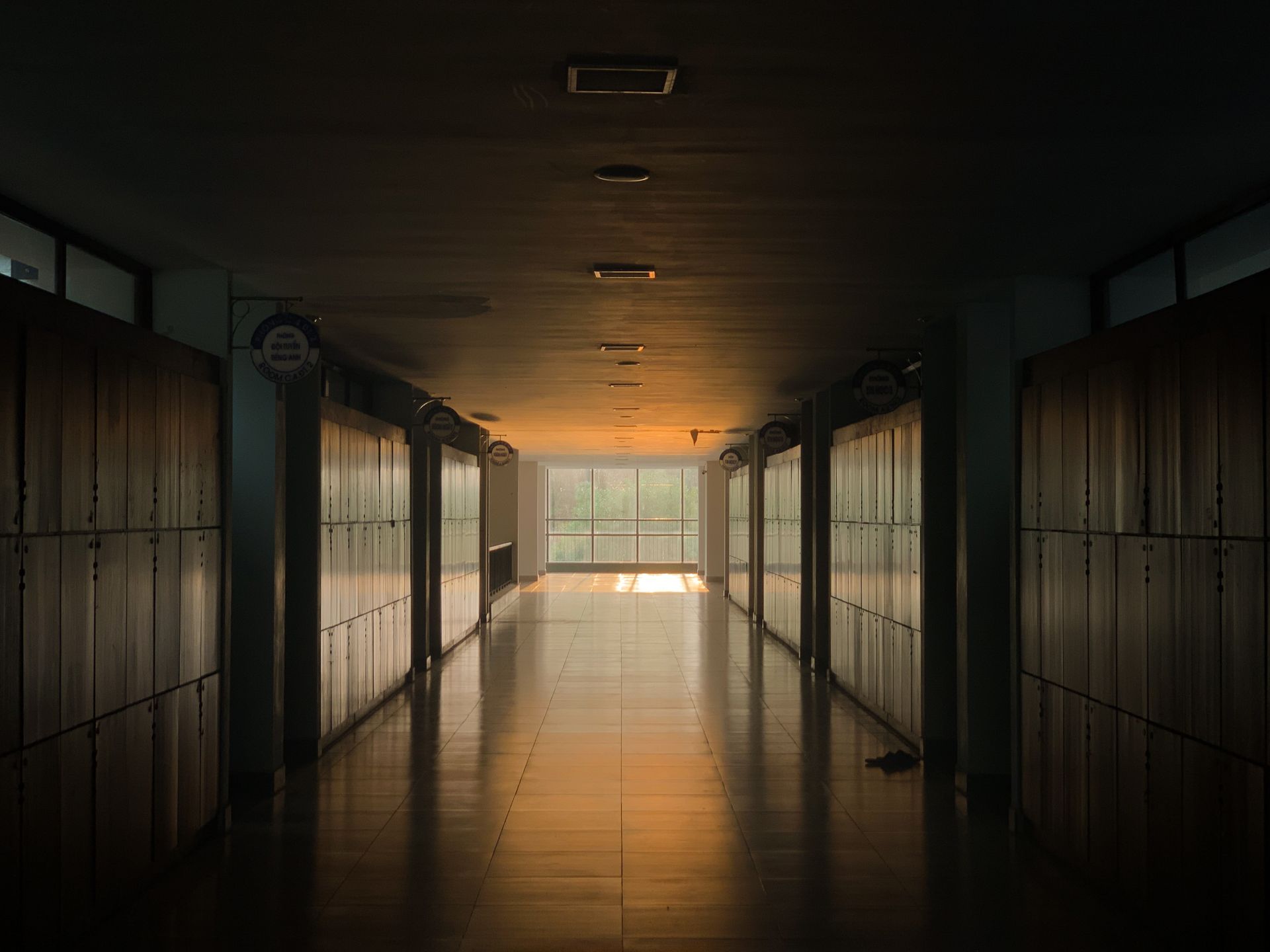 An empty school corridor lit by a grey morning light from the windows.