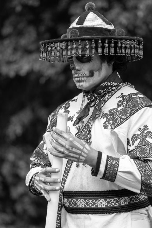 Free Black and white photo of a person wearing Catrina attire with detailed embroidery, skull makeup, and a decorated hat. Stock Photo
