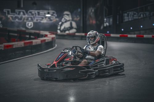 Free Exciting indoor go-kart racing scene with driver speeding on track. Stock Photo