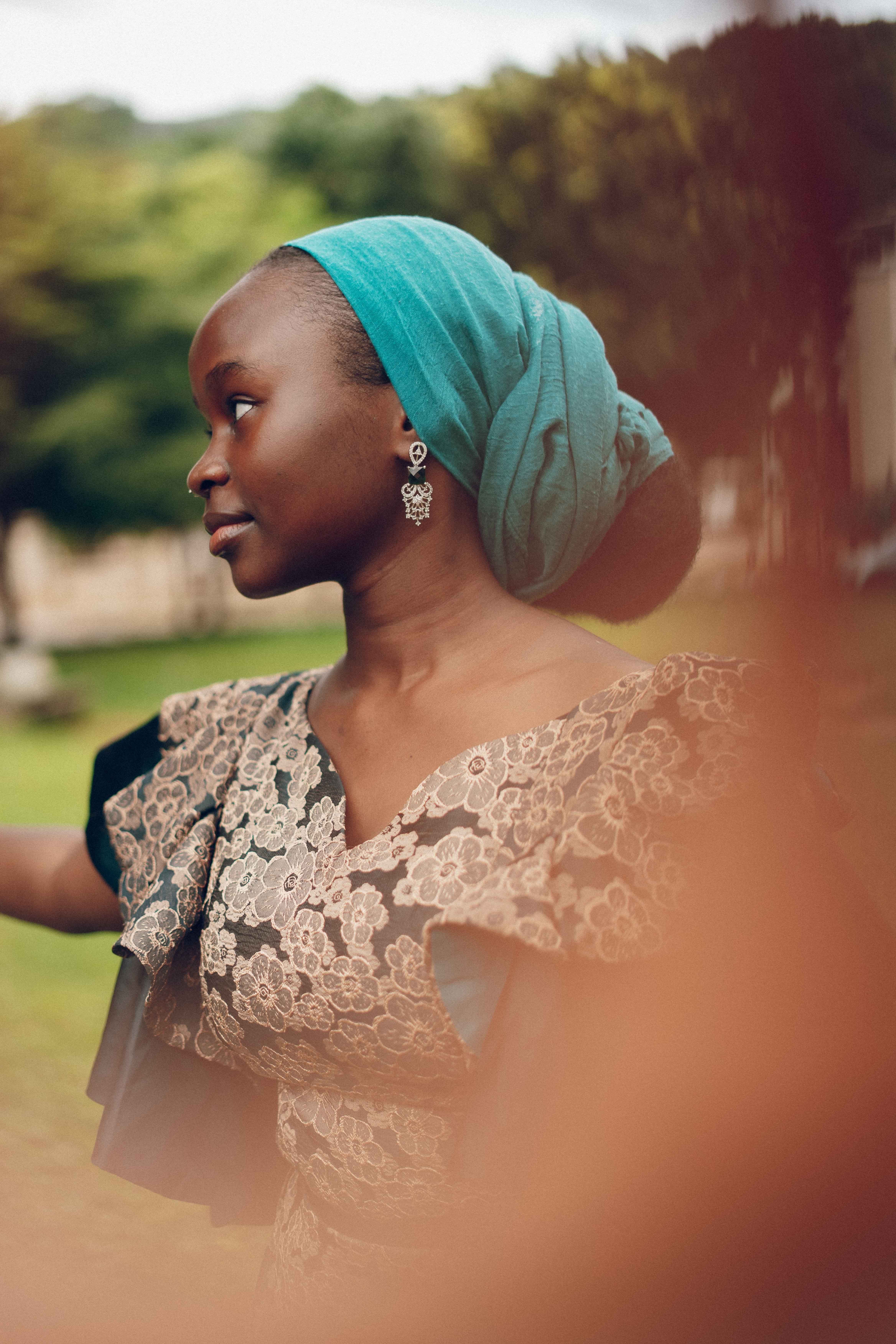 Portrait of a beautiful Nigerian woman in traditional attire with a serene outdoor background, showcasing African elegance.