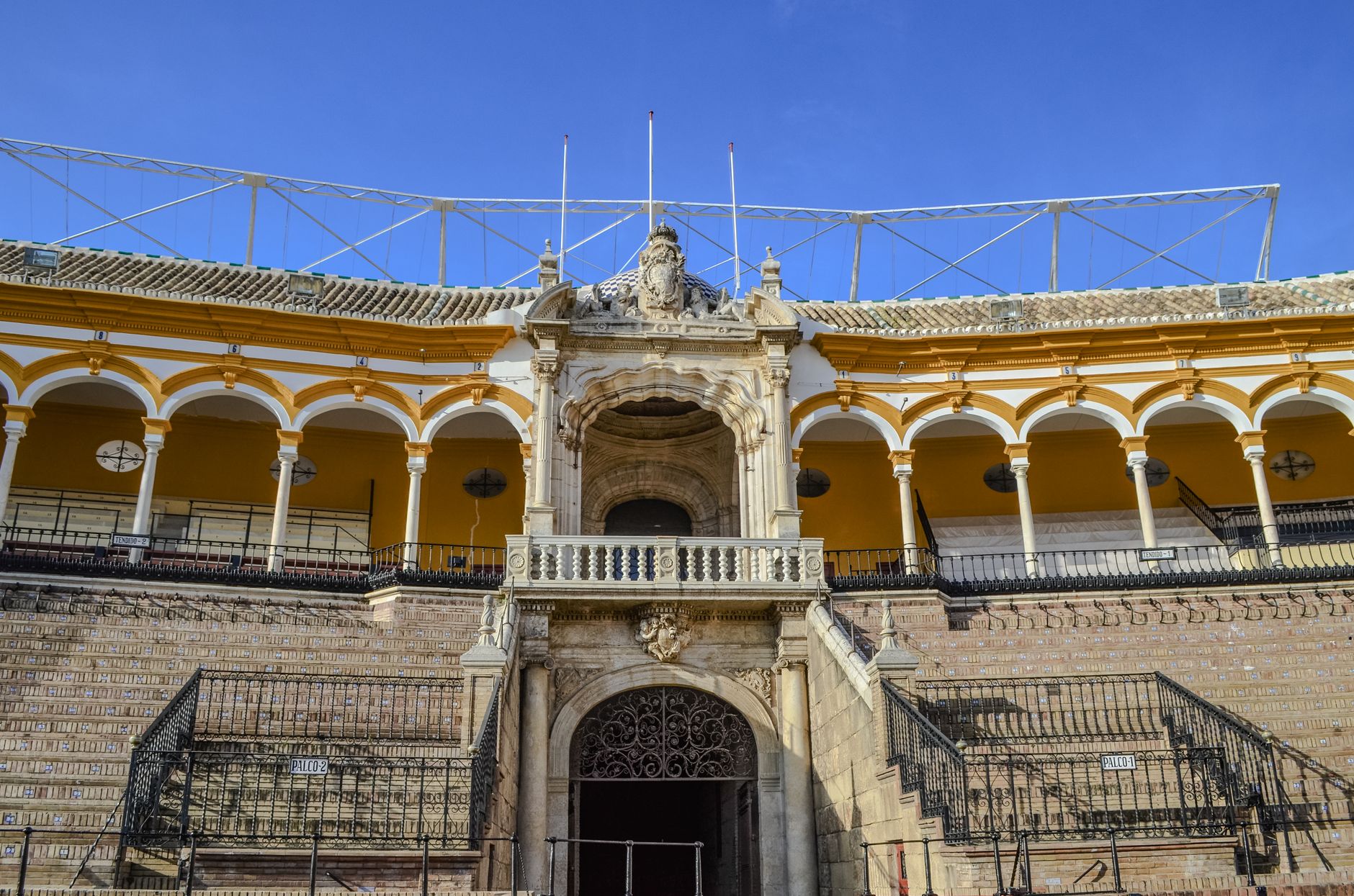 Discover the architectural beauty of Seville's iconic bullring, Plaza de Toros, bathed in sunlight.