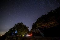 在森林覆盖的悬崖上，停着的汽车捕捉到了令人惊叹的星空，展现了自然与天文学之美