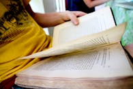 室内，一个人正翻阅着一本打开的书