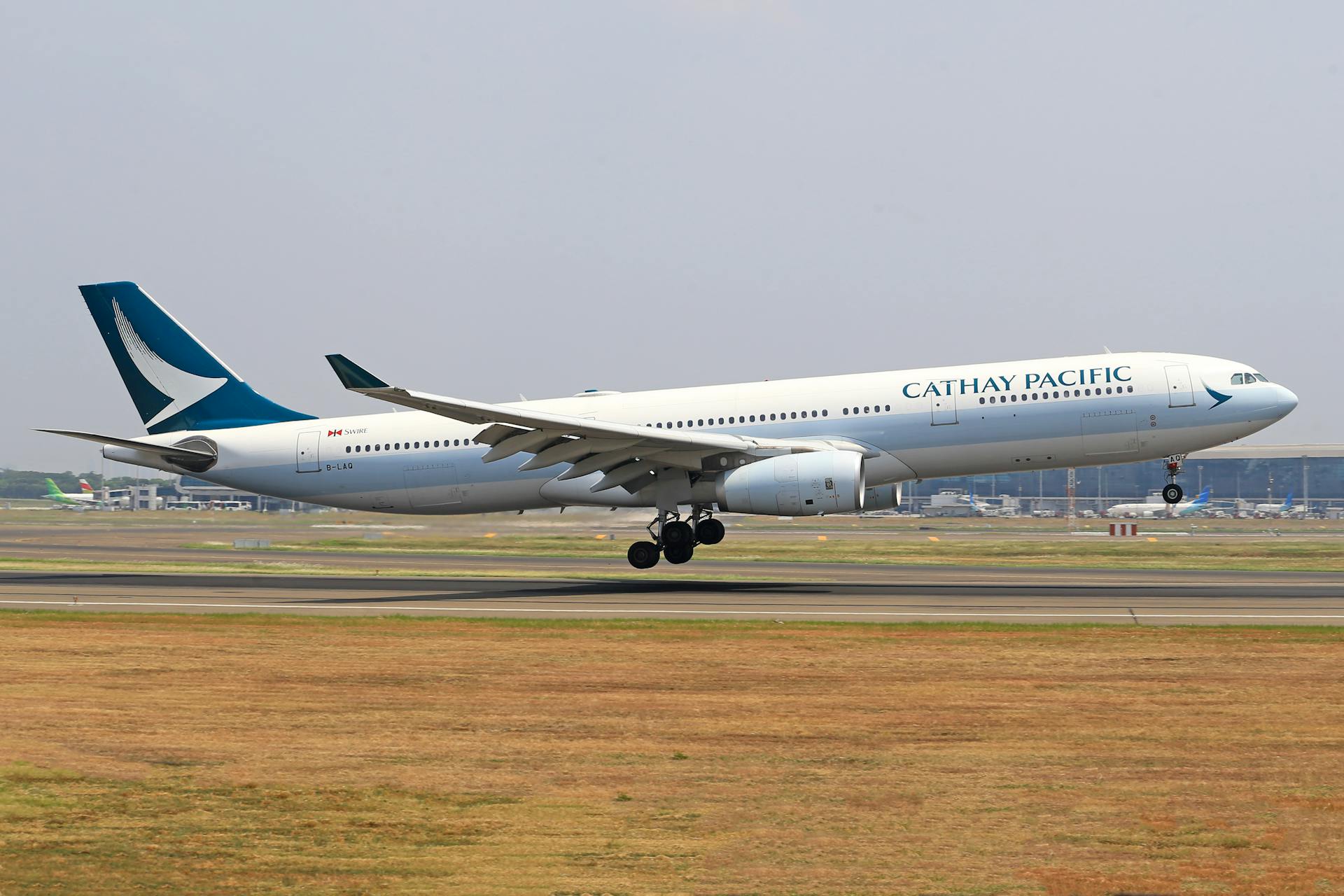 Cathay Pacific airplane taking off, featuring aircraft and aviation scene.