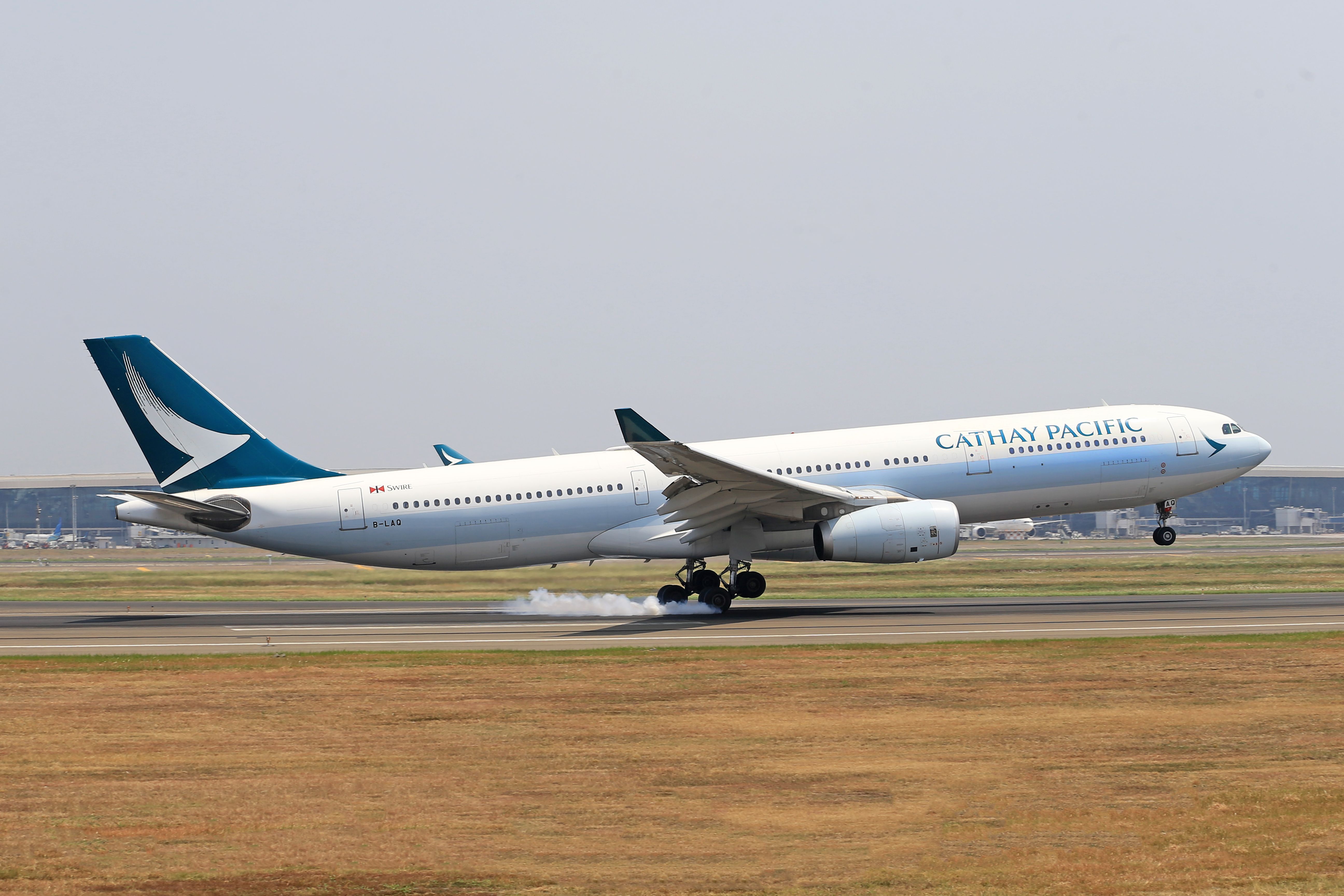 キャセイパシフィック航空のエアバスA330が滑走路に着陸し、車輪から煙が立ち上っています。 Via Pexels (by Jeffry Surianto)