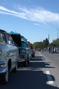 Classic cars displayed at an outdoor show on a sunny day. Perfect for automotive enthusiasts.