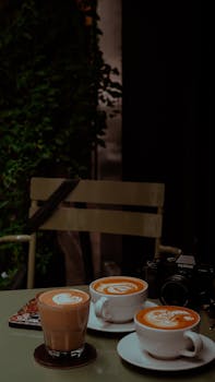 Artistic cafe setting featuring lattes and a Fujifilm camera, perfect for lifestyle enthusiasts.