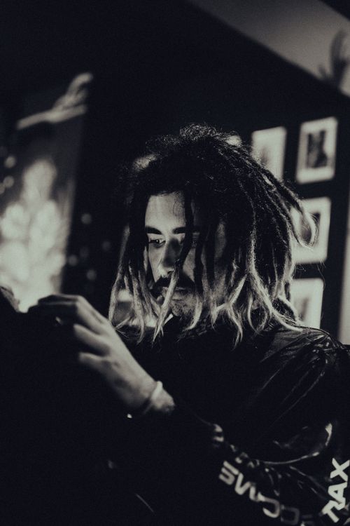 Free Moody portrait of a young man with dreadlocks in a tattoo shop. Stock Photo