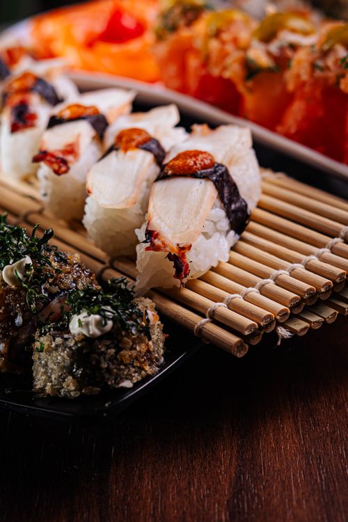 Free Assorted sushi rolls artfully arranged on a bamboo mat. Perfect for cuisine enthusiasts. Stock Photo