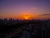 在充满活力的日落天空映衬下，摩天大楼的轮廓展现出令人惊叹的城市景观