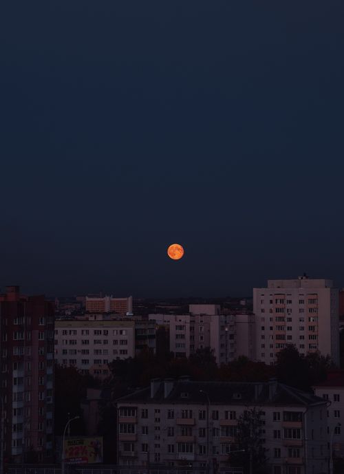 Free Captivating view of the full moon rising above the cityscape of Minsk, Belarus, at night. Stock Photo