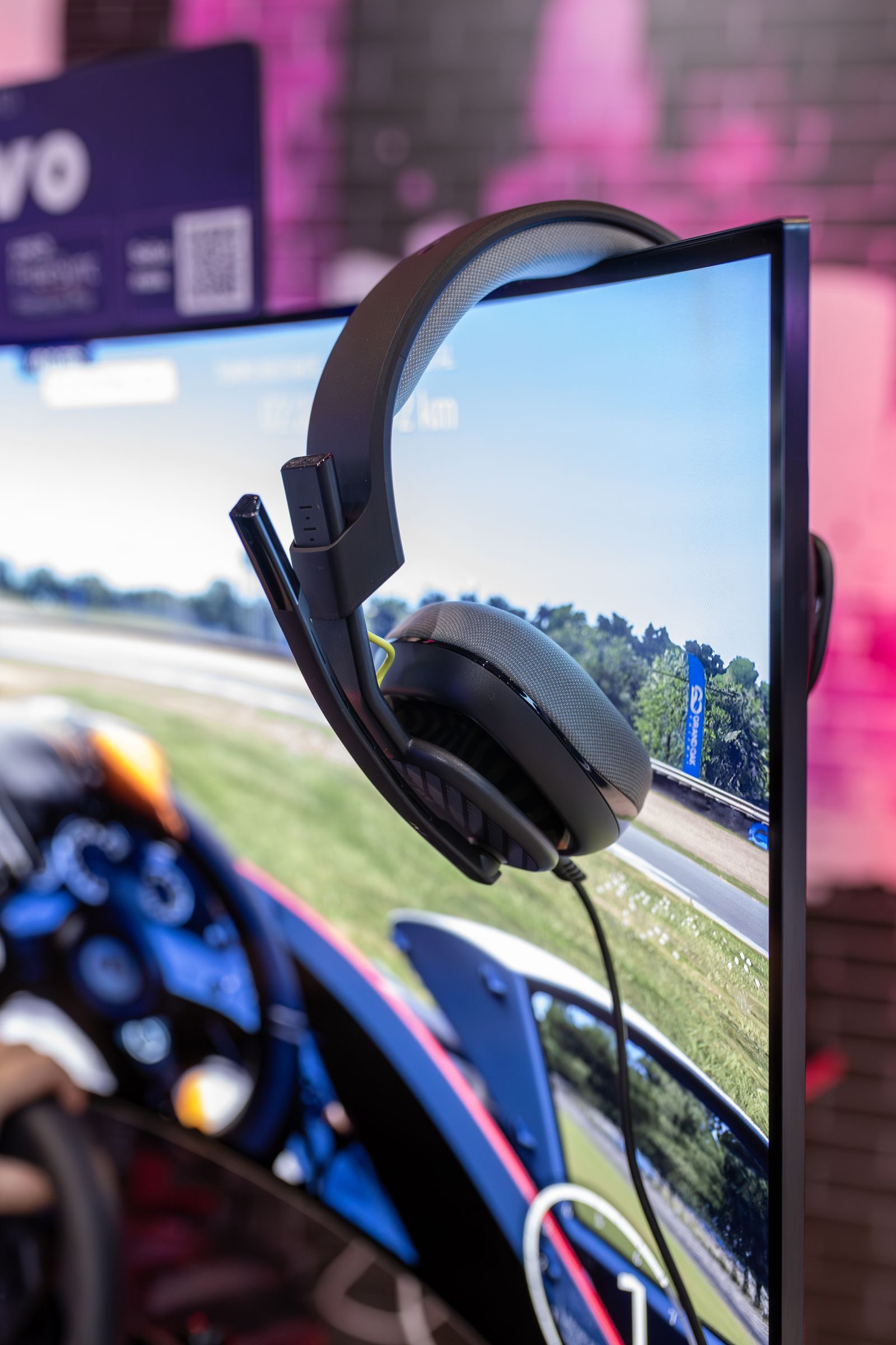 Gaming headset positioned on a curved monitor in a modern gaming environment