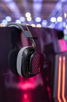 Gaming headset hanging against a vibrant background with bokeh lights, showcasing modern tech style.