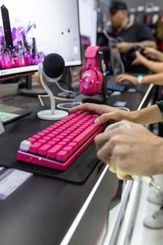 Close-up of a vibrant gaming setup featuring a pink keyboard and headset, ideal for streamers.