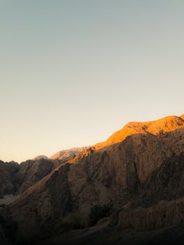 Sunrise over Dahab's rugged mountains, casting a golden glow, South Sinai, Egypt.