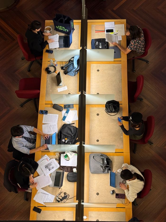 Group of students preparing together using laptops and notebooks
