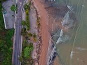 无人机镜头展现了卡波布兰科海滩的海岸线，以沙质海岸、海浪和邻近的道路为特色