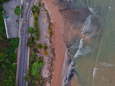 无人机镜头展现了卡波布兰科海滩的海岸线，以沙质海岸、海浪和邻近的道路为特色
