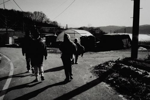 Free Group of people walking in a rural South Korean village, showcasing local life. Stock Photo