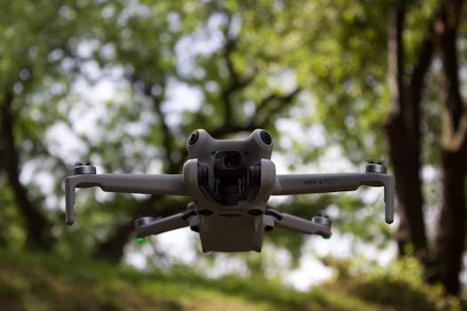 Close-up of a Mini 4 Pro drone hovering in a green forest.
