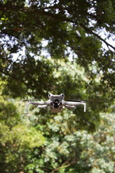 A drone hovering amid dense green trees, capturing nature from above.