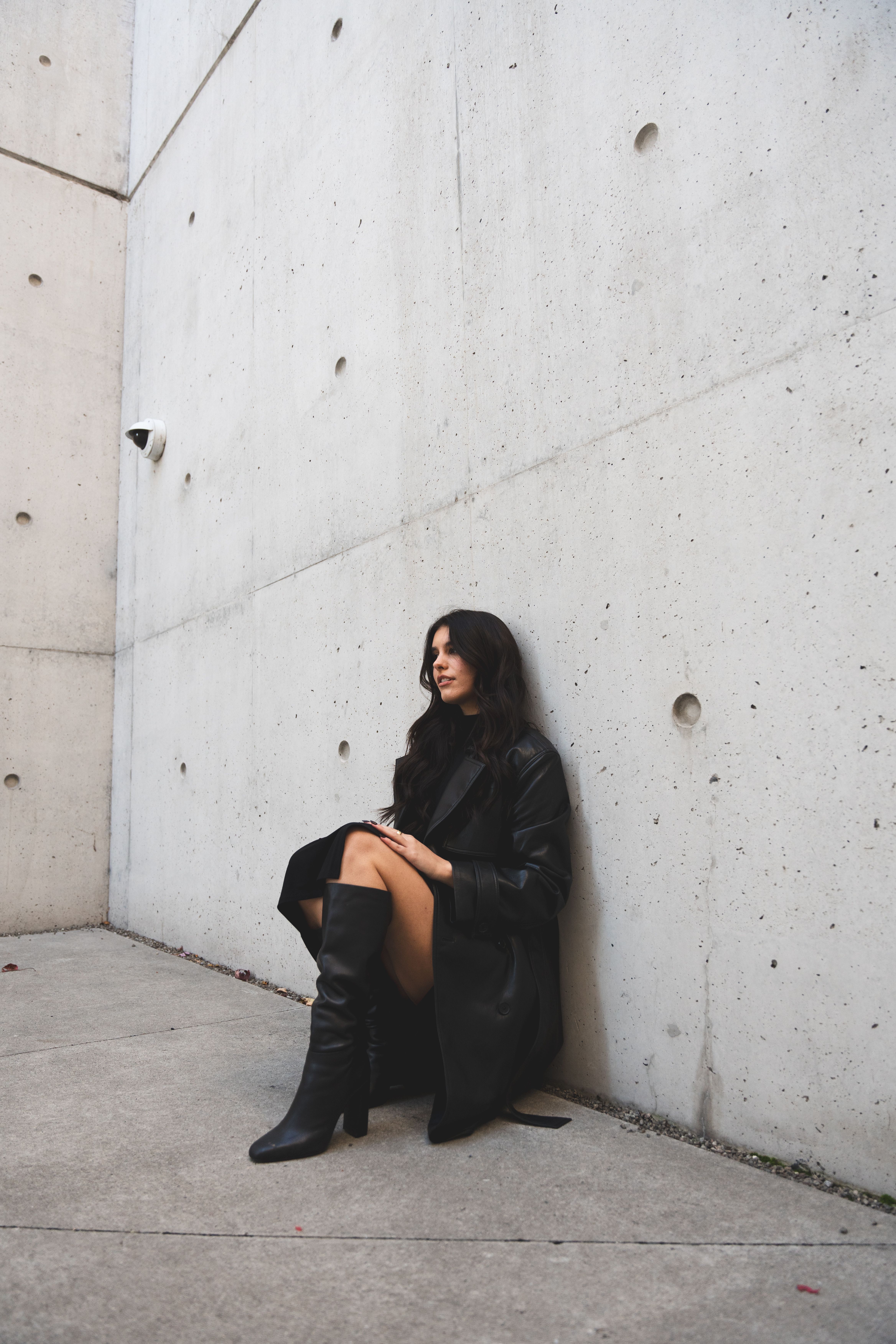 Fashionable Woman in Black Dress Against Concrete Wall · Free Stock Photo