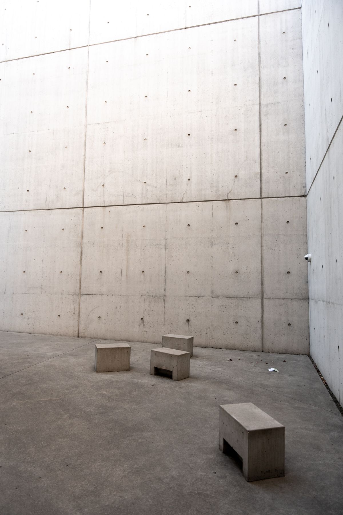 An abstract minimalist arrangement of concrete blocks and seating in an outdoor setting.