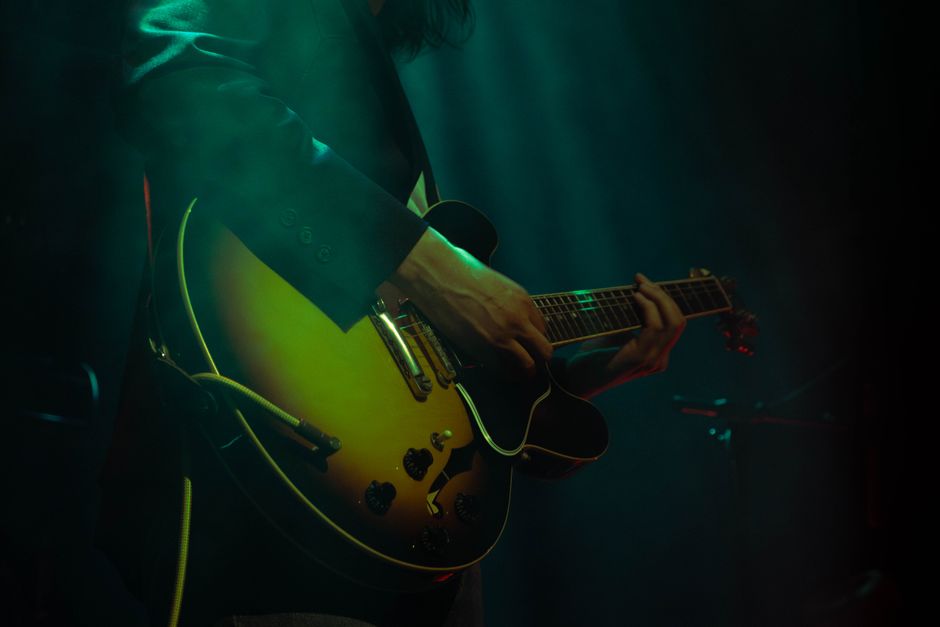 A musician skillfully playing an electric guitar under concert lights.