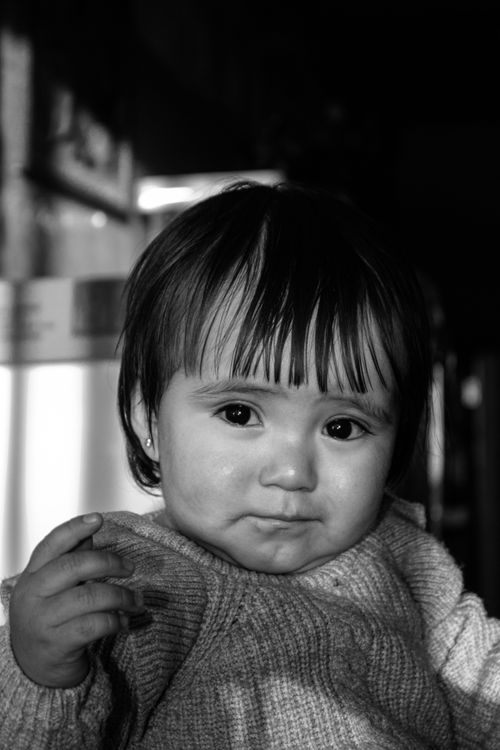 Free A captivating grayscale portrait of a baby with expressive eyes, indoors. Stock Photo