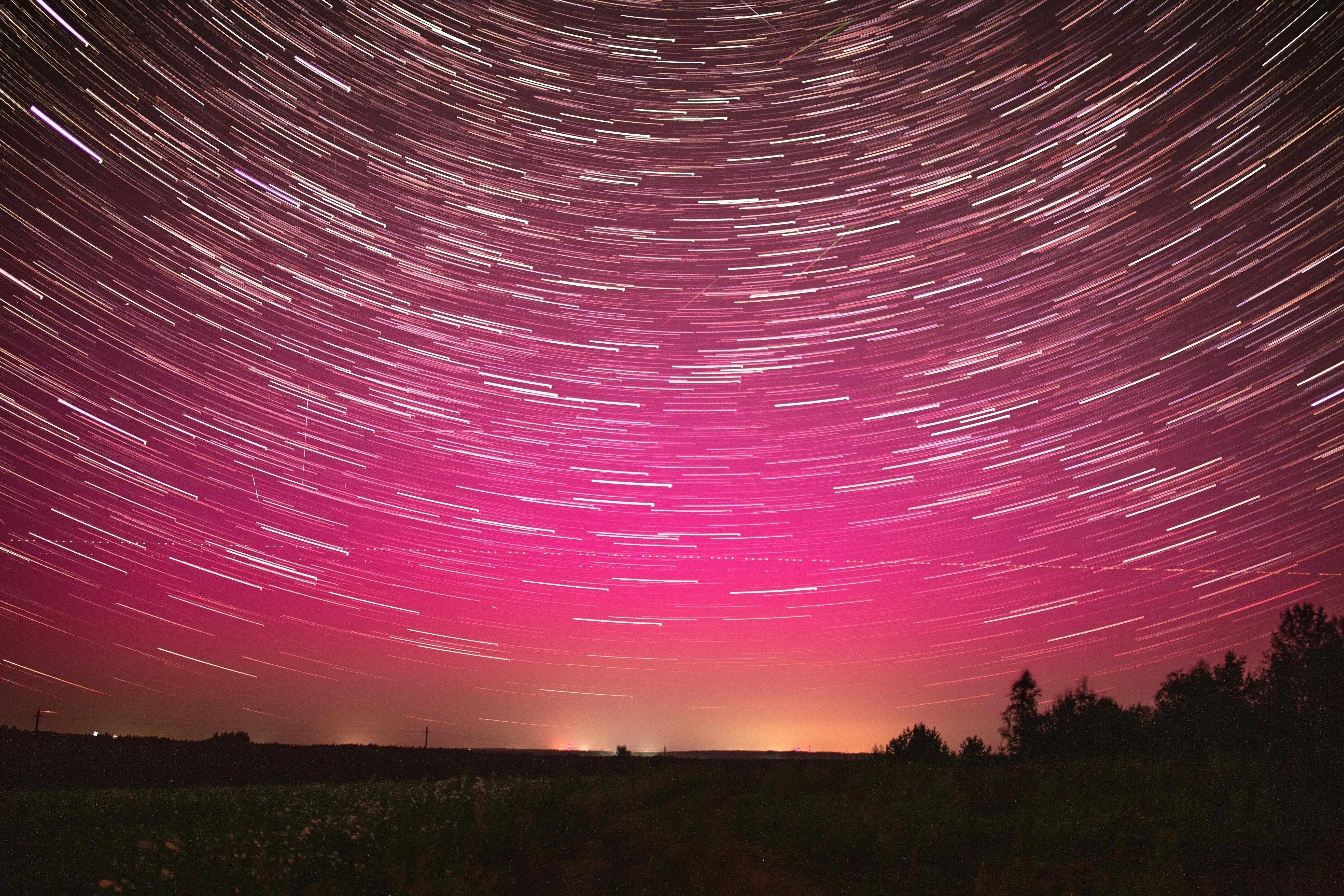 Mesmerizing long exposure shot of star trails over Belarus night sky with vibrant colors.