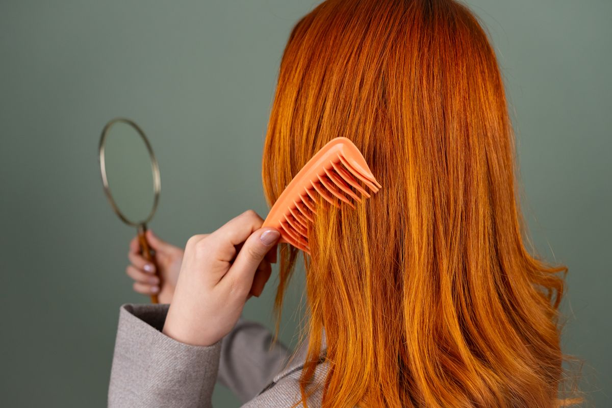 Copper-red hair being combed in the studio