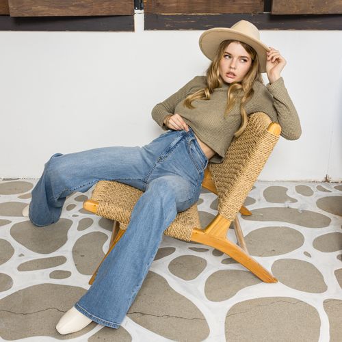 Free Young woman in vintage outfit lounging on a contemporary chair indoors. Stock Photo