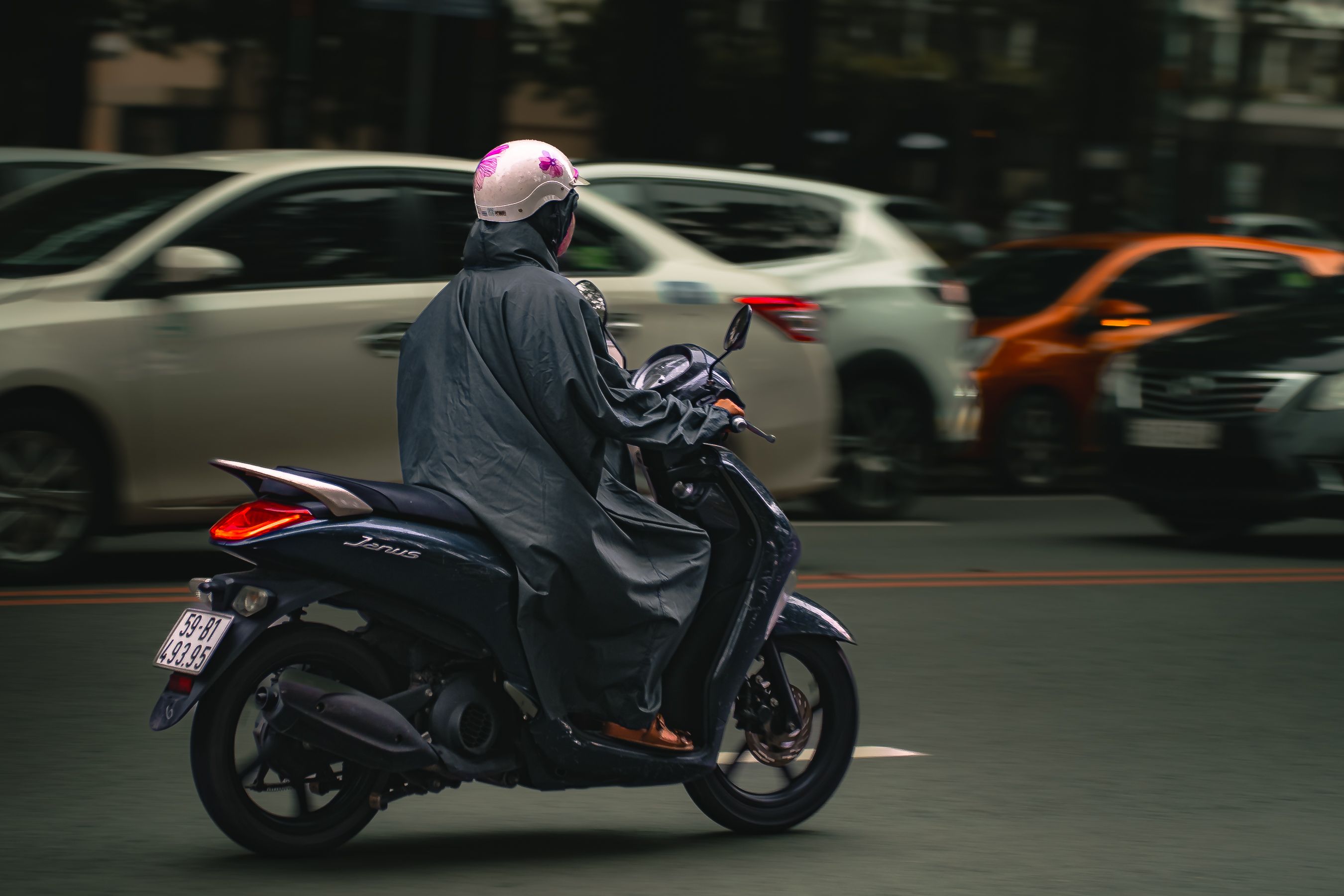 Person Riding Scooter on Busy Urban Road · Free Stock Photo