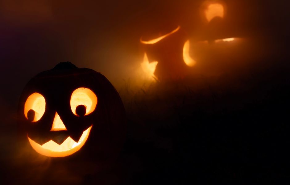 Como Lidar com o Perfeccionismo e Buscar a Autenticidade 2 Eerie jack-o'-lanterns glowing in the fog, creating a spooky Halloween atmosphere.